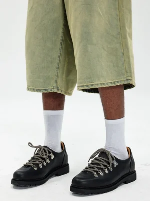 Black metal-eyelet Derby shoes styled with cropped olive wide-leg pants and white crew socks