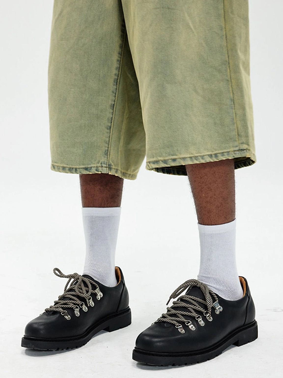Black metal-eyelet Derby shoes styled with cropped olive wide-leg pants and white crew socks
