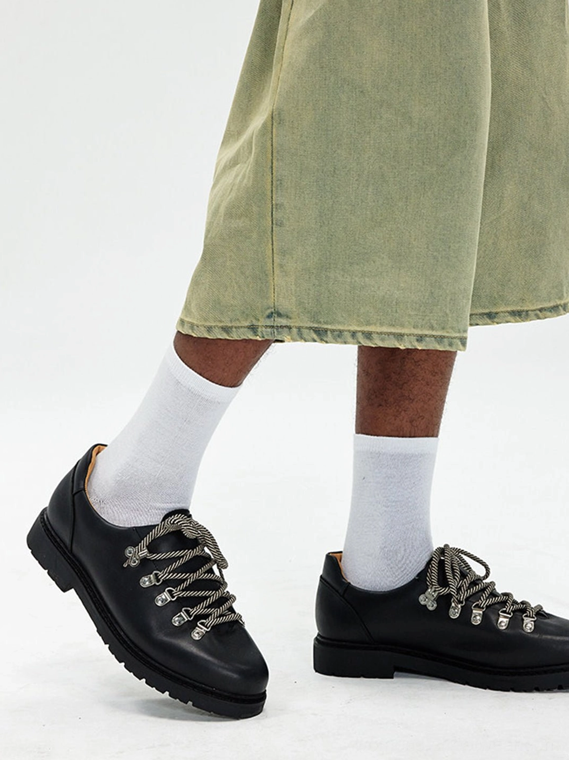 Black textured Derby shoes with silver metal eyelets shown in a streetwear three-quarter side outfit view