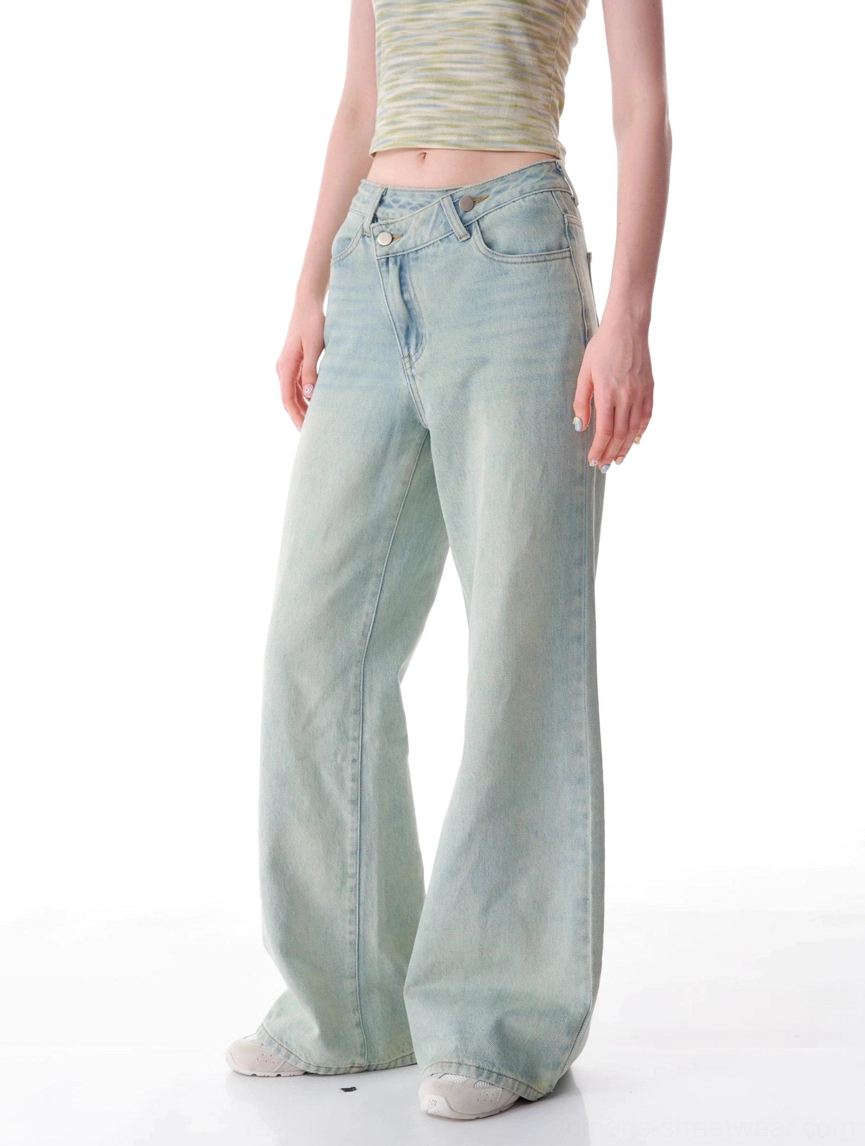 Three-quarter view of women's asymmetrical light wash wide leg jeans with relaxed fit and vintage denim fading