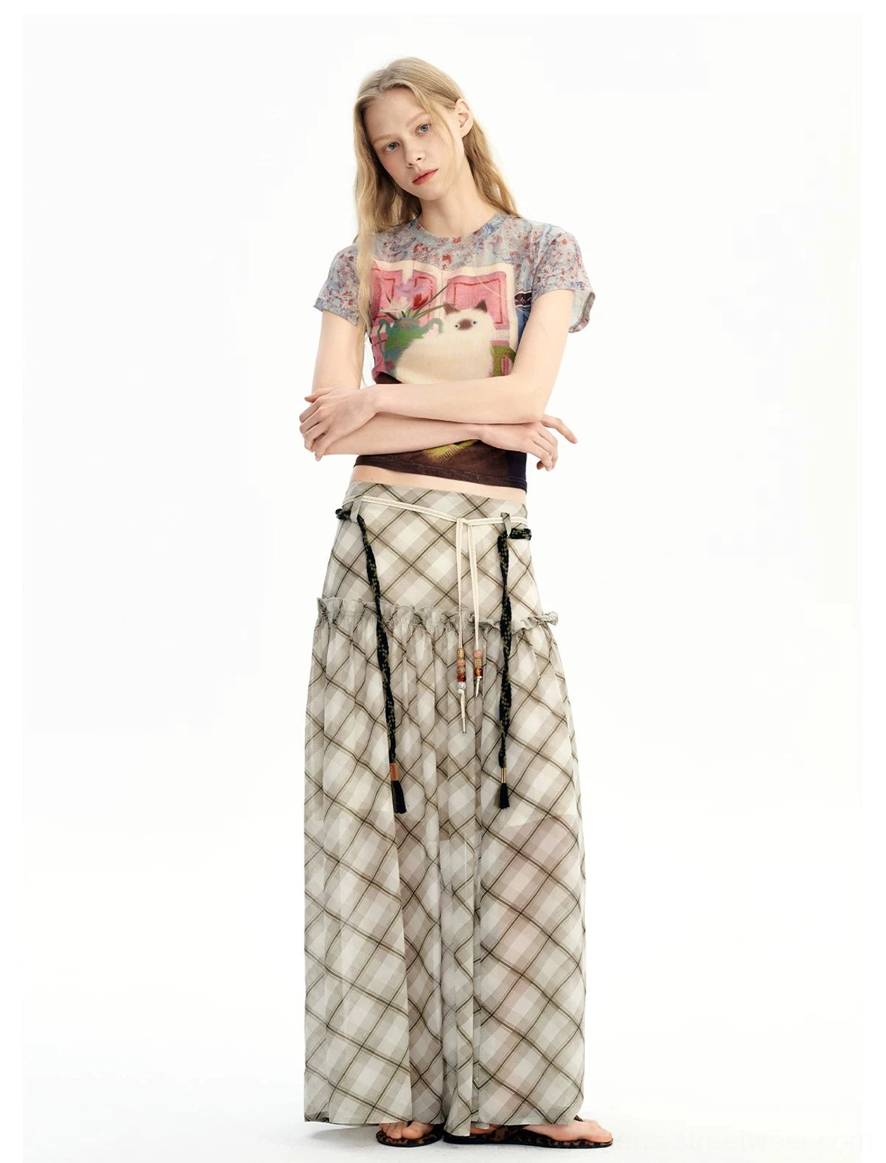 Front outfit view of a tiered plaid chiffon maxi skirt with lightweight fabric, cropped top, and black slides