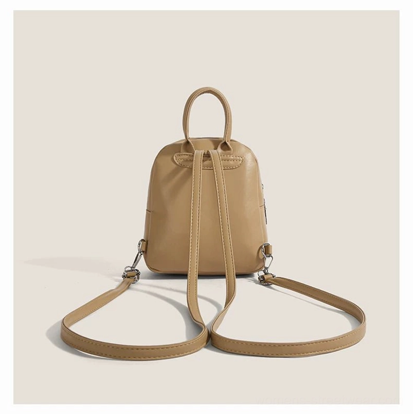 Rear view of a compact toast beige kawaii cat mini backpack with stitched back panel, dual padded shoulder straps, adjustable details, and top faux leather carry loop