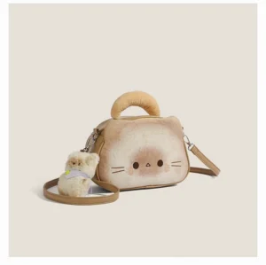 Toast cat barrel crossbody bag in bread beige with brown trim, detachable shoulder strap and plush cat charm front three-quarter view