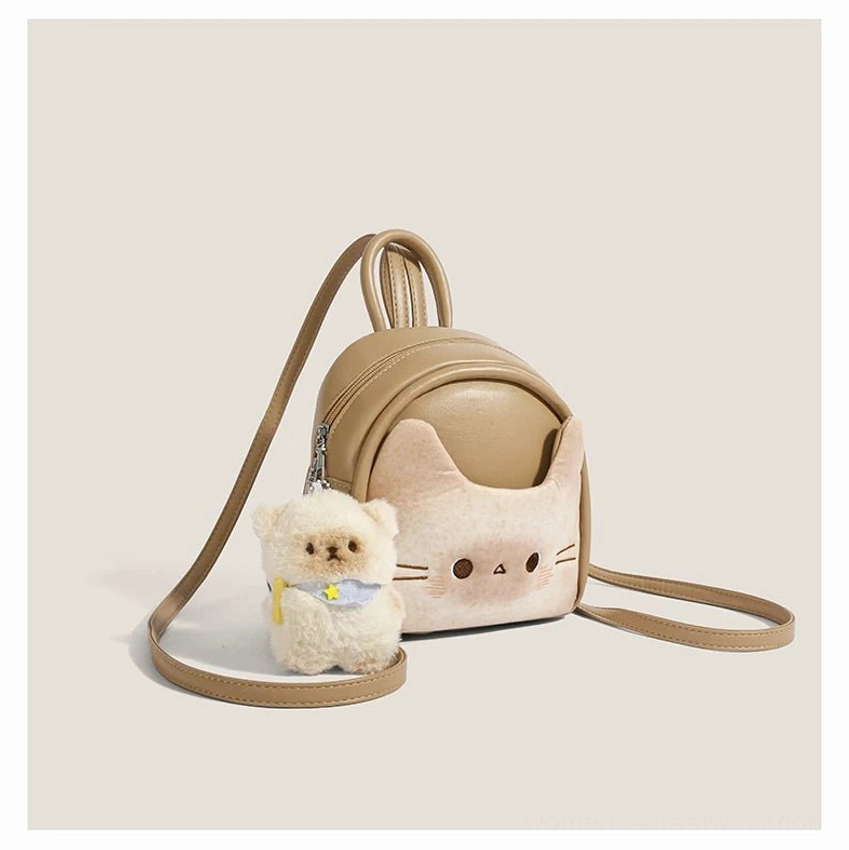 Right side three quarter view of a toast beige kawaii mini backpack showing the top carry handle, adjustable rear strap hardware, rounded silhouette, and puppy charm