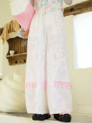 Close-up of pink cartoon printed Tooth Fairy wide leg streetwear pants with polka dot panels and tassel trim
