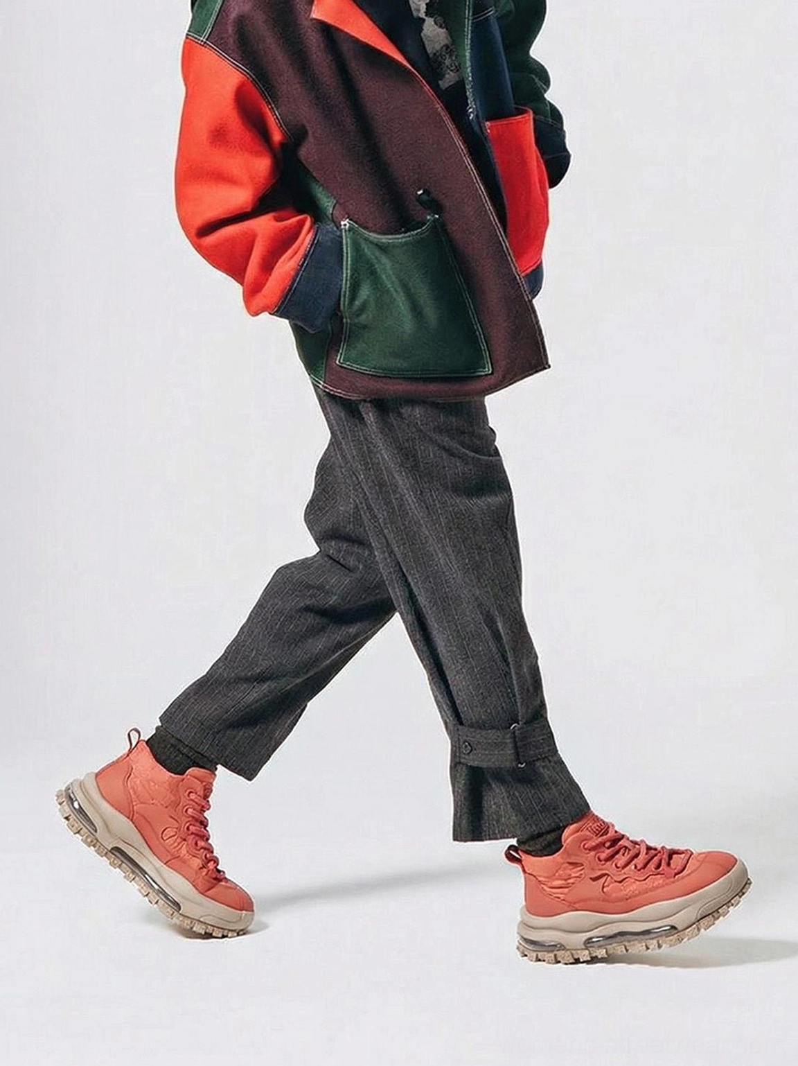 Terracotta trail platform sneakers worn with cropped trousers and colorblock streetwear outfit in walking pose