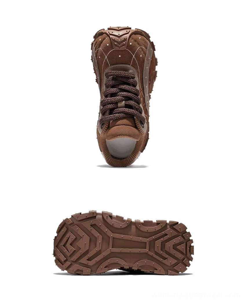 Brown TrailGrid chunky sneakers shown from the front with thick round laces, structured rounded toe cap, layered leather upper, and rugged outsole bottom