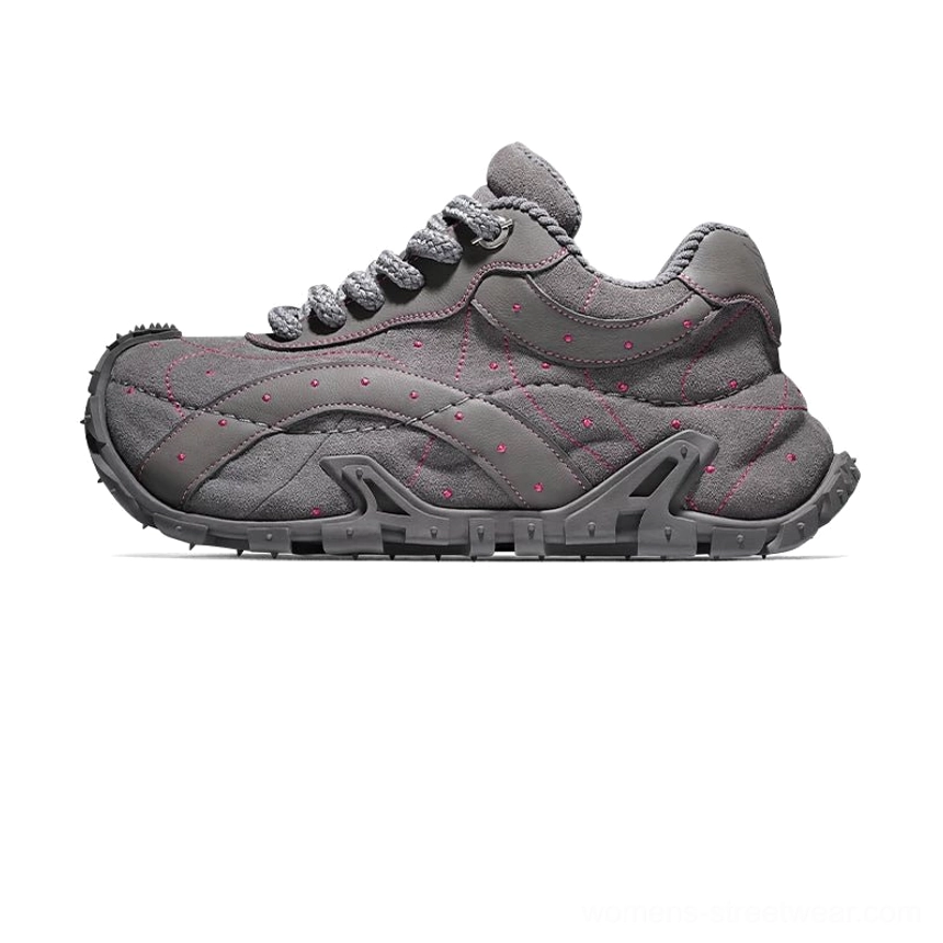Dark gray TrailGrid chunky streetwear sneaker with pink contrast stitching, decorative dot details, oversized sole, and structured layered side panels