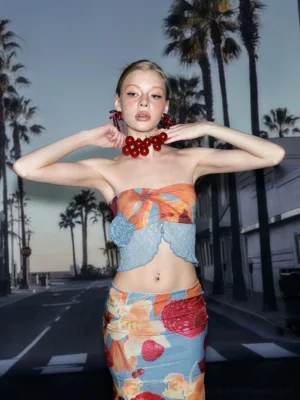 Close-up view of a tropical fruit print strapless crop top with blue lace trim and slim fitted silhouette