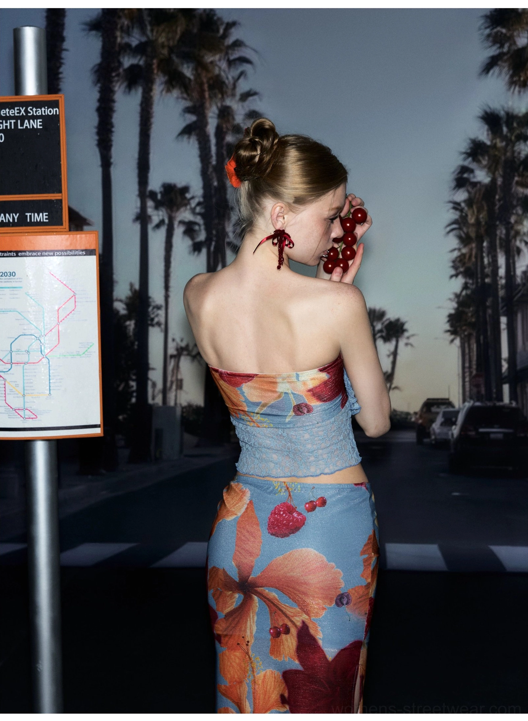 Back view of a tropical print strapless crop top showing the lace panel and coordinated streetwear styling