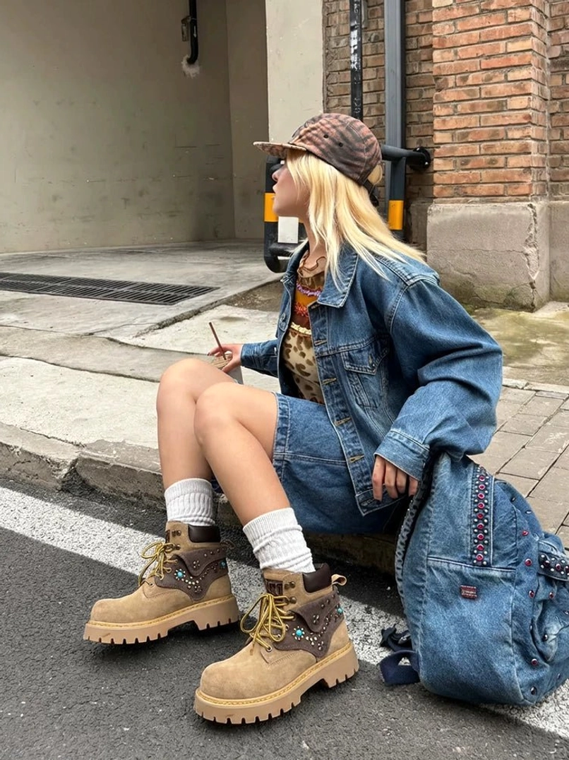 Close streetwear styling view of turquoise embellished ankle boots with denim clothing and visible western metal decoration