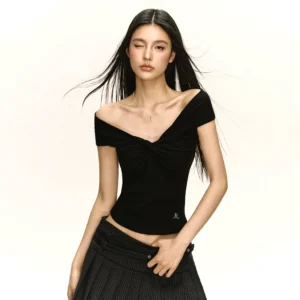 Black-inspired twist front off-shoulder fitted crop top styling with pleated skirt and Korean streetwear silhouette