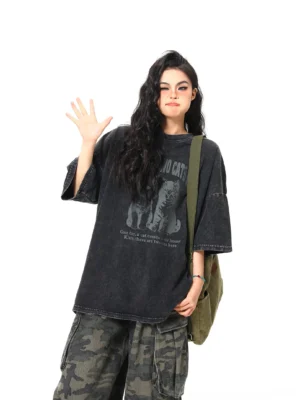 Black two cats washed oversized vintage graphic streetwear tee styled with camouflage cargo pants in a front full-body view