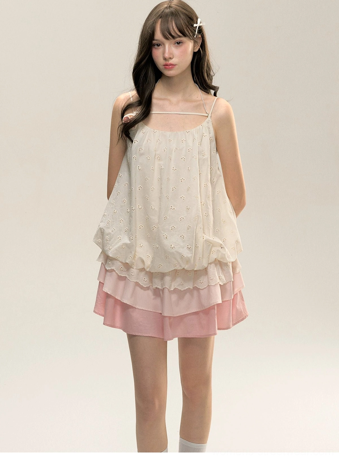 Front close-up view of two-tone cream and pink tiered ruffle cami mini dress with double spaghetti straps and embroidered bodice