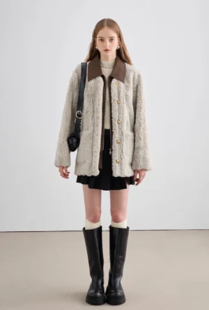 Full body outfit view of gray two-tone faux fur coat styled with black pleated mini skirt and knee-high boots