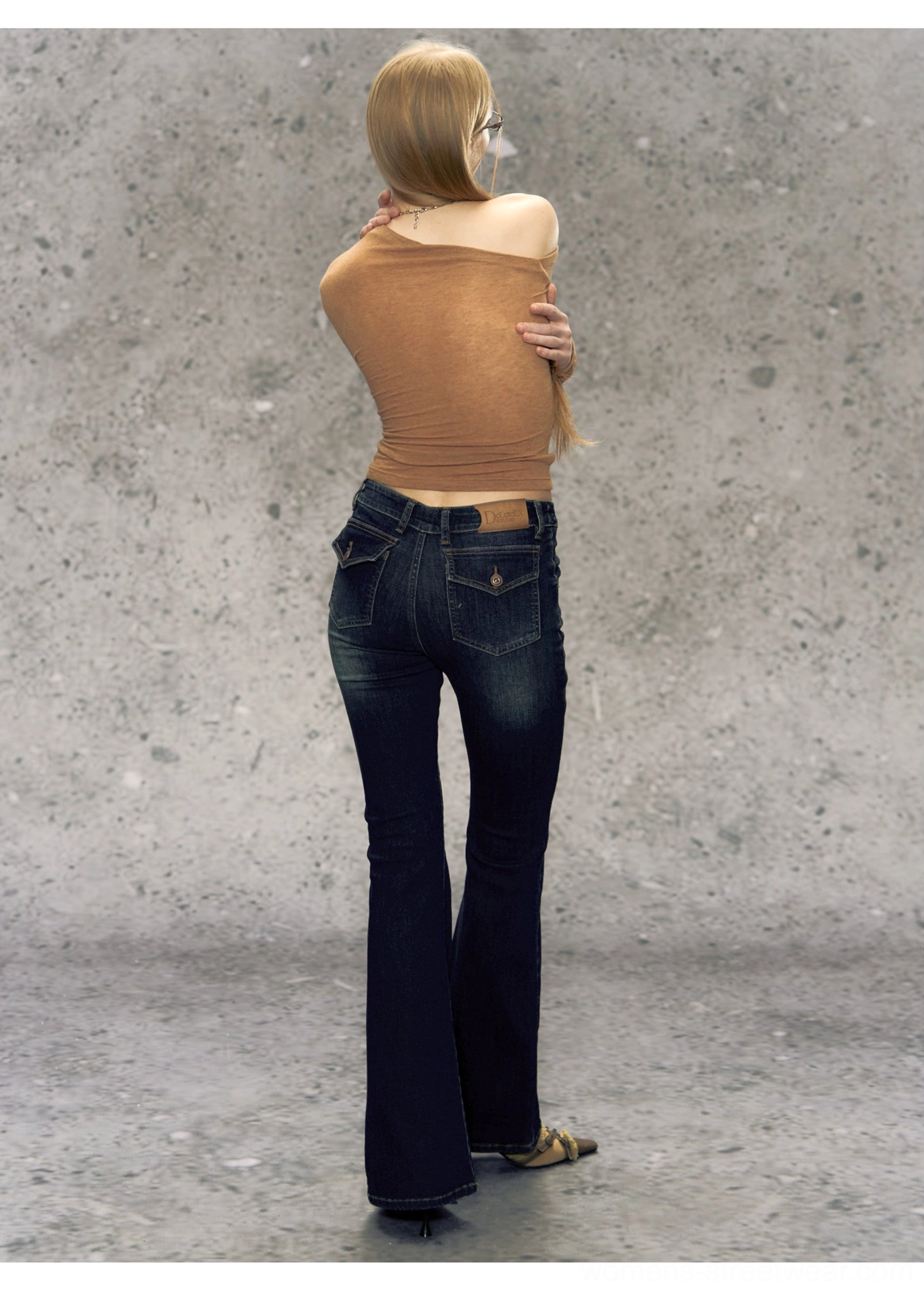 Dark blue washed high-waisted micro flare jeans back view showing rear pockets, faded thigh details, and long flared hems