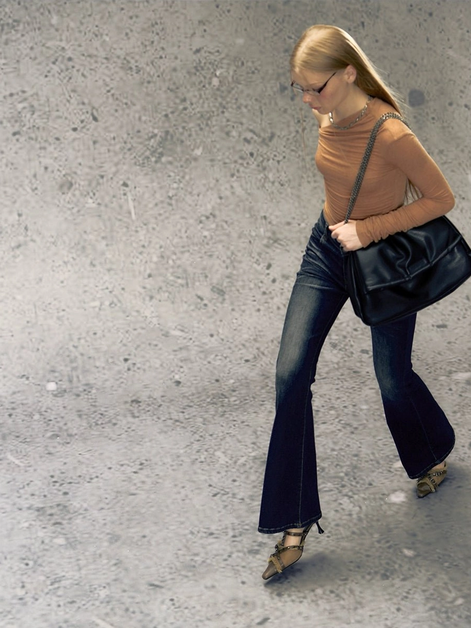 Dark blue two-tone high-waisted micro flare jeans shown in a side walking view with faded denim wash and slim flared silhouette