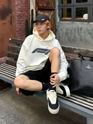 Young man wearing two-tone black and off-white platform canvas skate shoes with casual streetwear outfit and leather tote bag outdoors