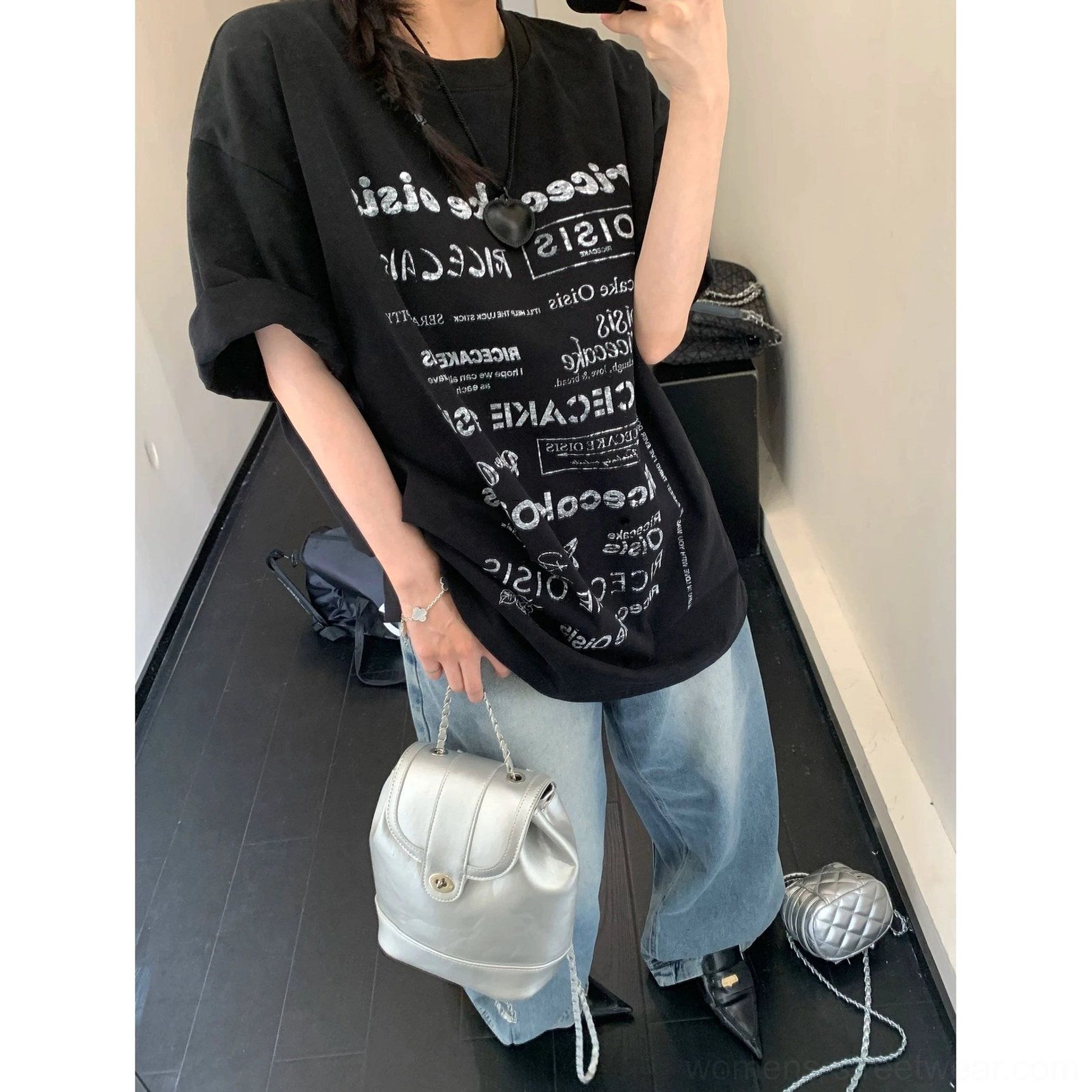 Back view of black typographic riot oversized streetwear t-shirt with white reversed lettering print
