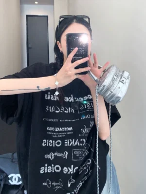 Black typographic riot oversized streetwear t-shirt front view with all-over white lettering and dropped shoulders