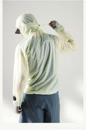 Rear full-body view of a model wearing the Lemon Green ultra-light UV protection hooded windbreaker with crinkled sheer fabric and thumbhole cuffs