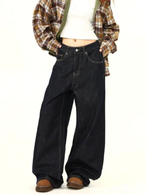 Front three quarter view of women wearing ultra wide leg mid waist dark denim jeans with contrast stitching and a relaxed Seoul streetwear silhouette
