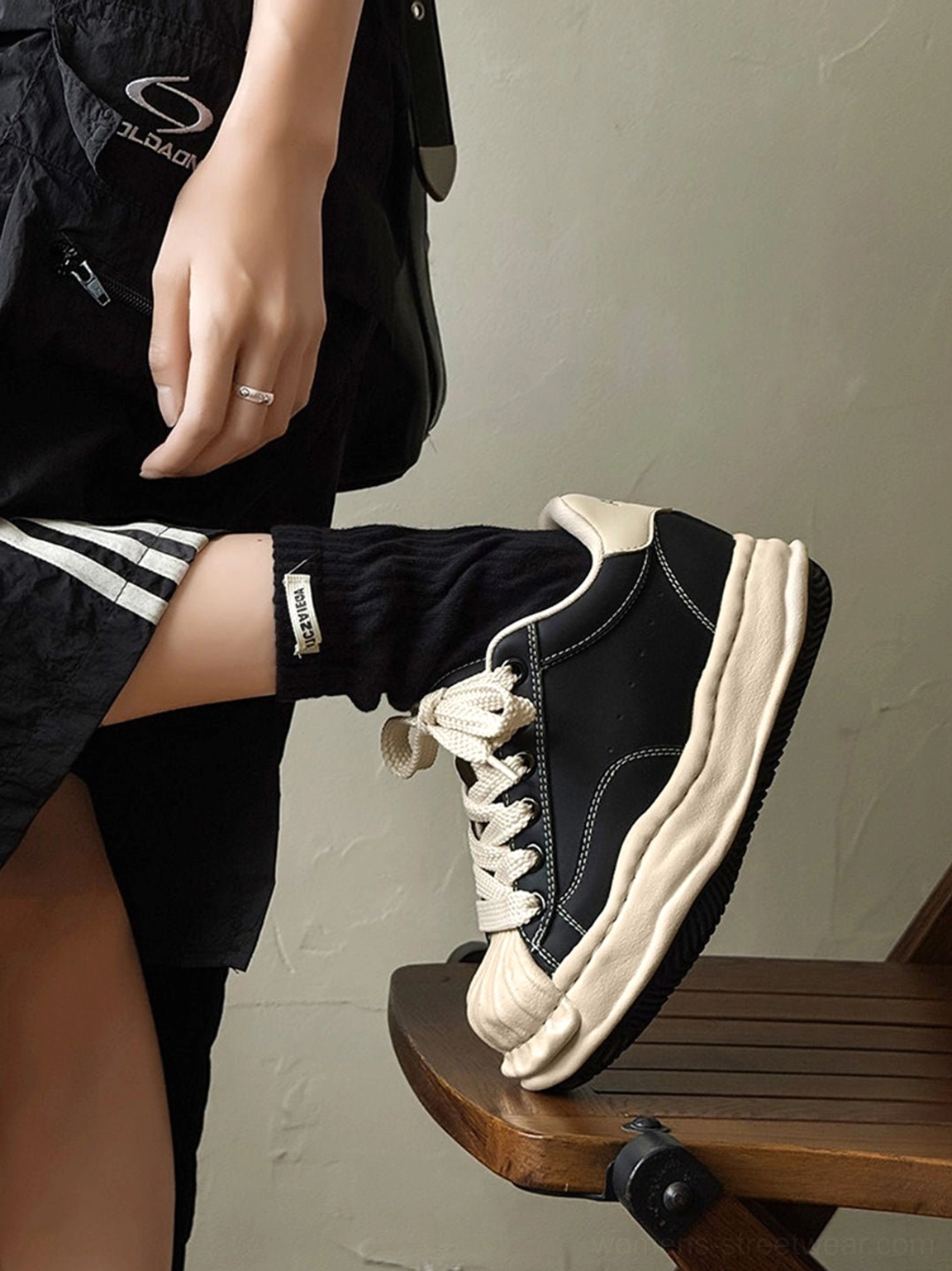 Unisex black distressed platform sneakers featuring rounded toe, padded collar, and substantial 7cm outsole