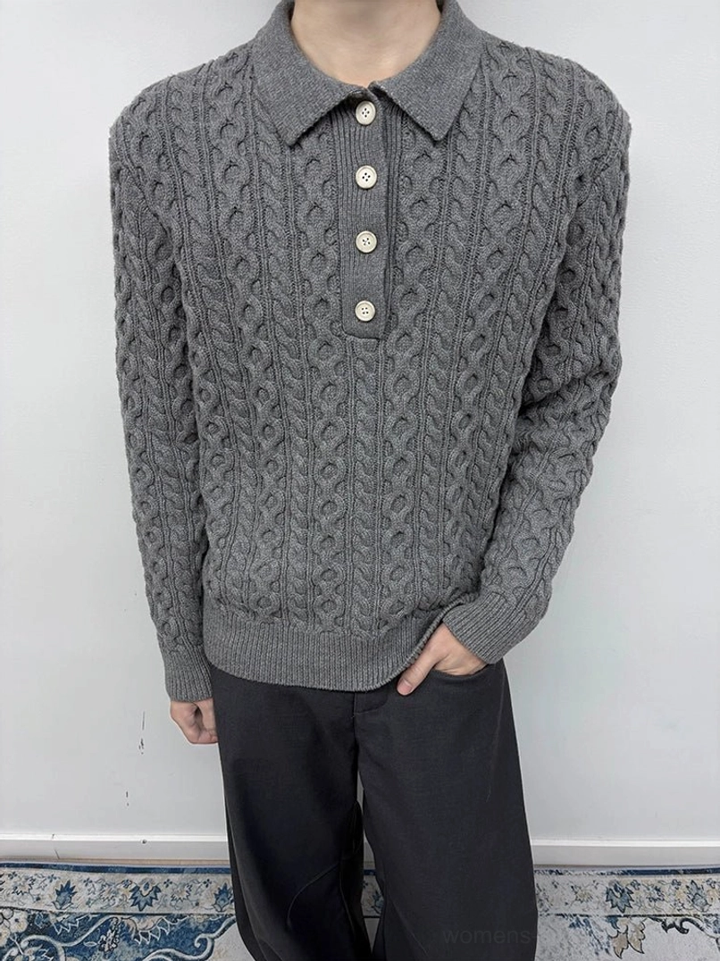 Dark gray cable knit polo collar sweater worn with loose black trousers in a relaxed streetwear outfit