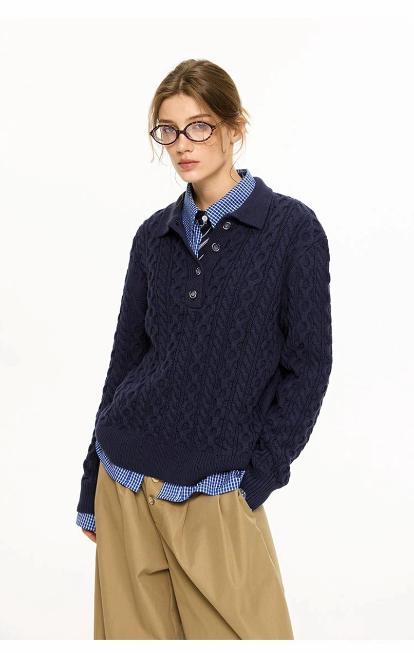 Female model wearing a navy blue cable knit polo collar sweater with layered checkered shirt styling