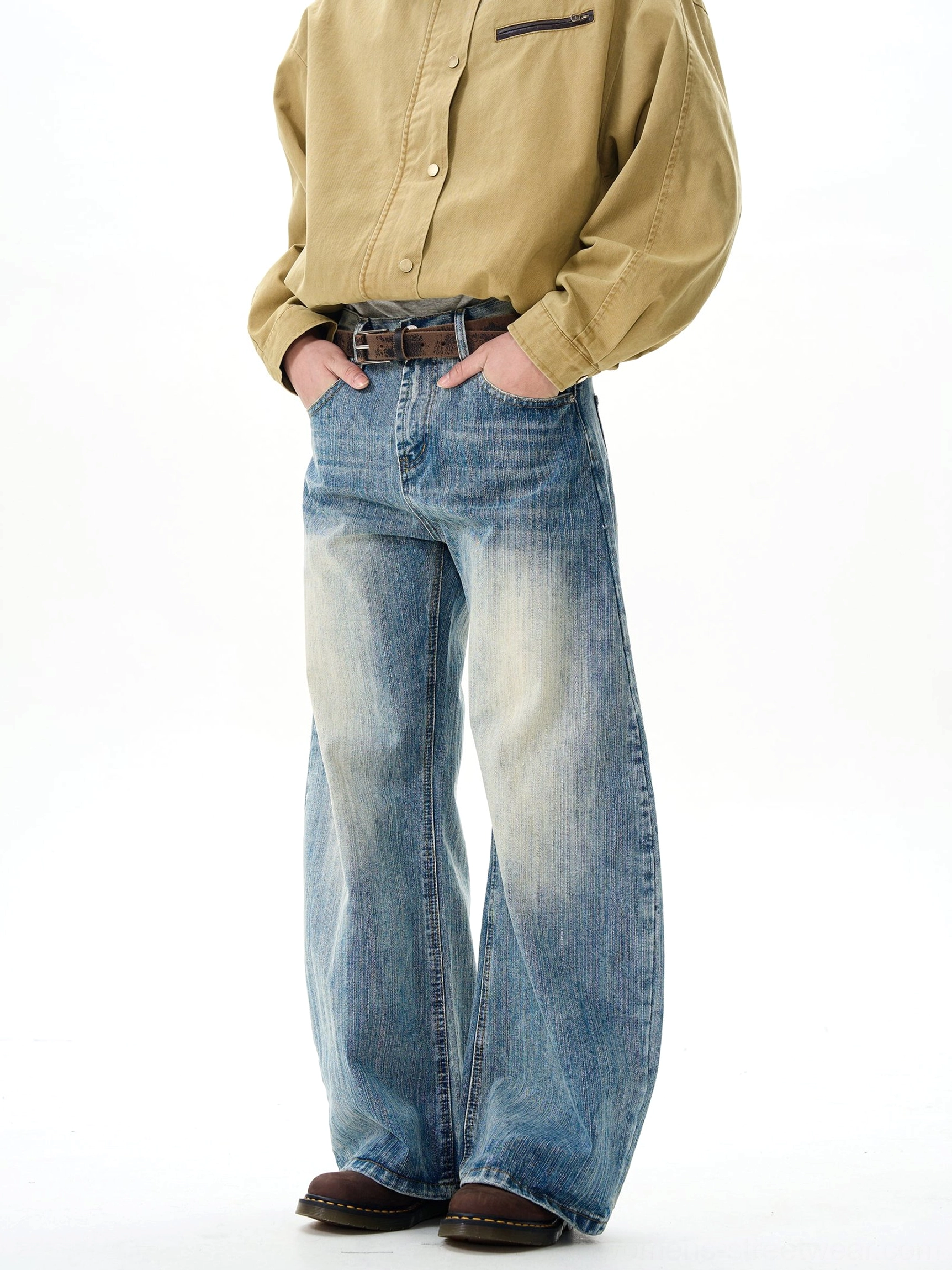 Three-quarter side view of unisex faded blue wide-leg denim jeans with relaxed fit, practical pockets, and vintage streetwear styling