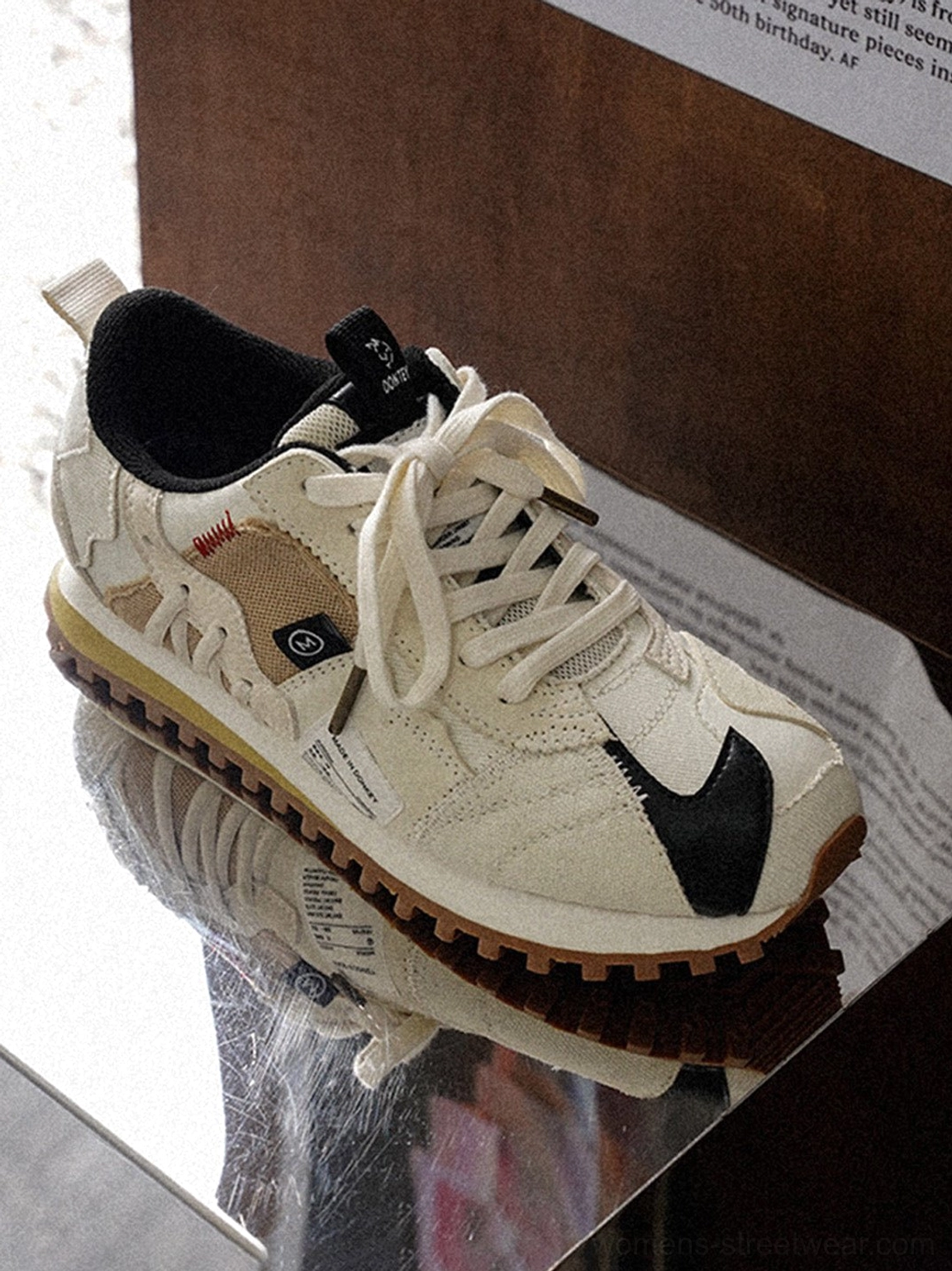 Unisex ivory streetwear sneakers with black contrast details, rounded toe, decorative stitching, and brown textured outsole