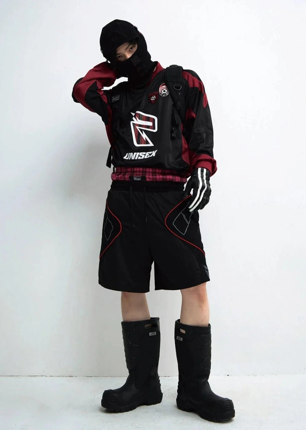 Layered black and wine red racing team streetwear sweatshirt outfit with plaid shirt hem backpack and tactical styling