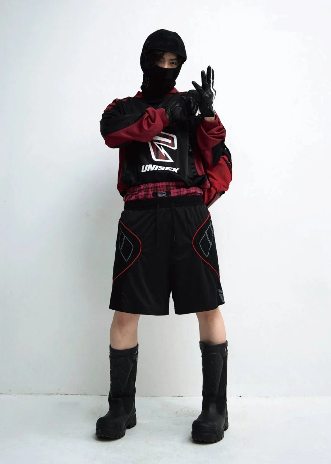 Male model wearing black racing team color block streetwear sweatshirt with athletic shorts and combat boots