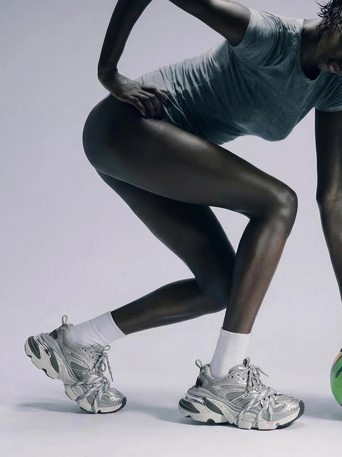 Unisex silver chunky platform sneakers worn by a female streetwear model showing dual lace system and textured outsole