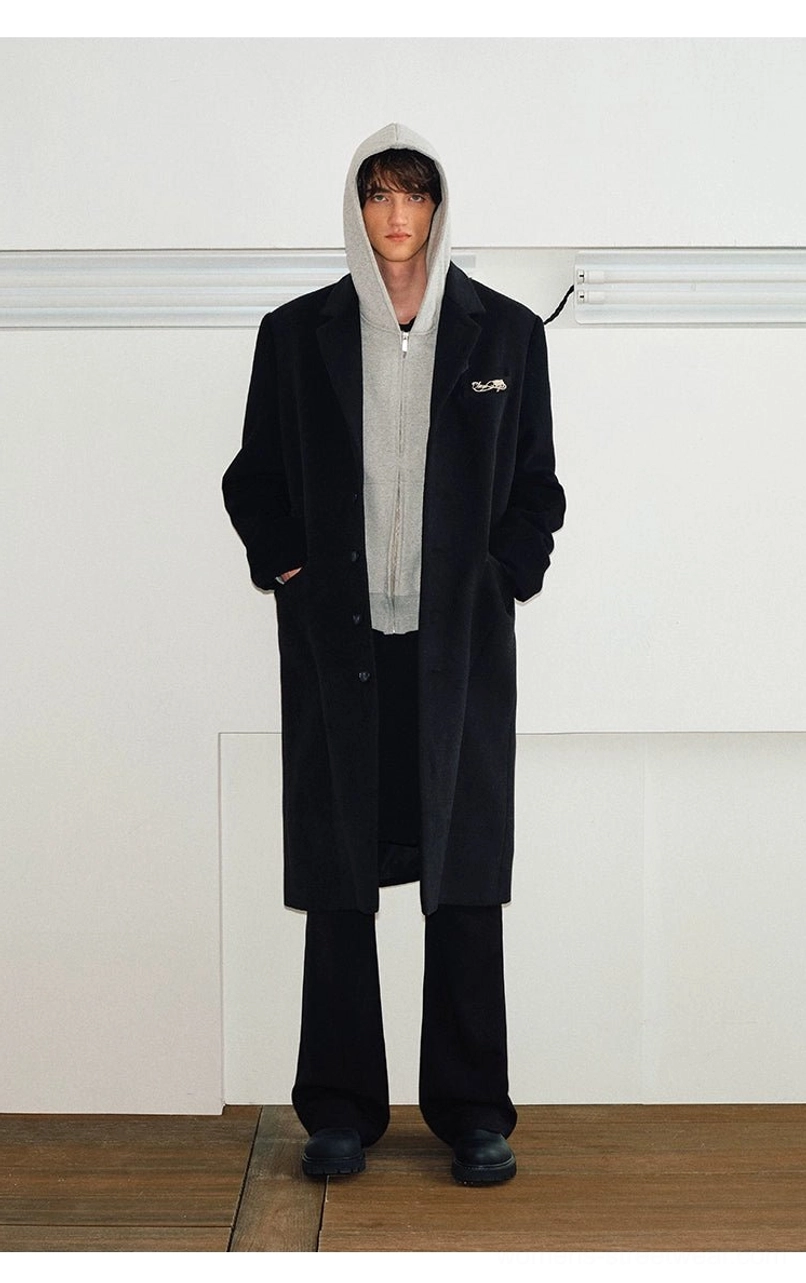 Black long stand collar wool blend overcoat layered over a grey hoodie for Korean streetwear styling