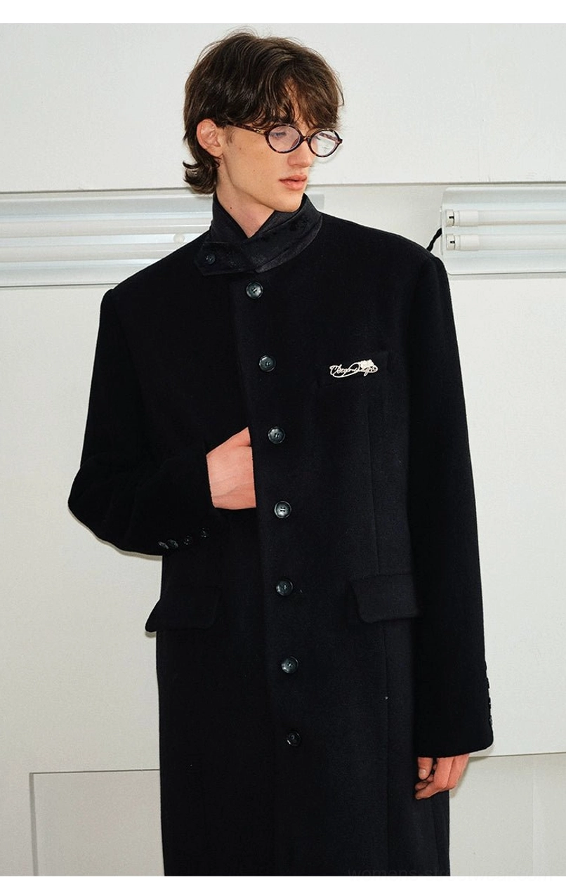 Black tailored long stand collar overcoat three quarter front view with button closure and side pocket