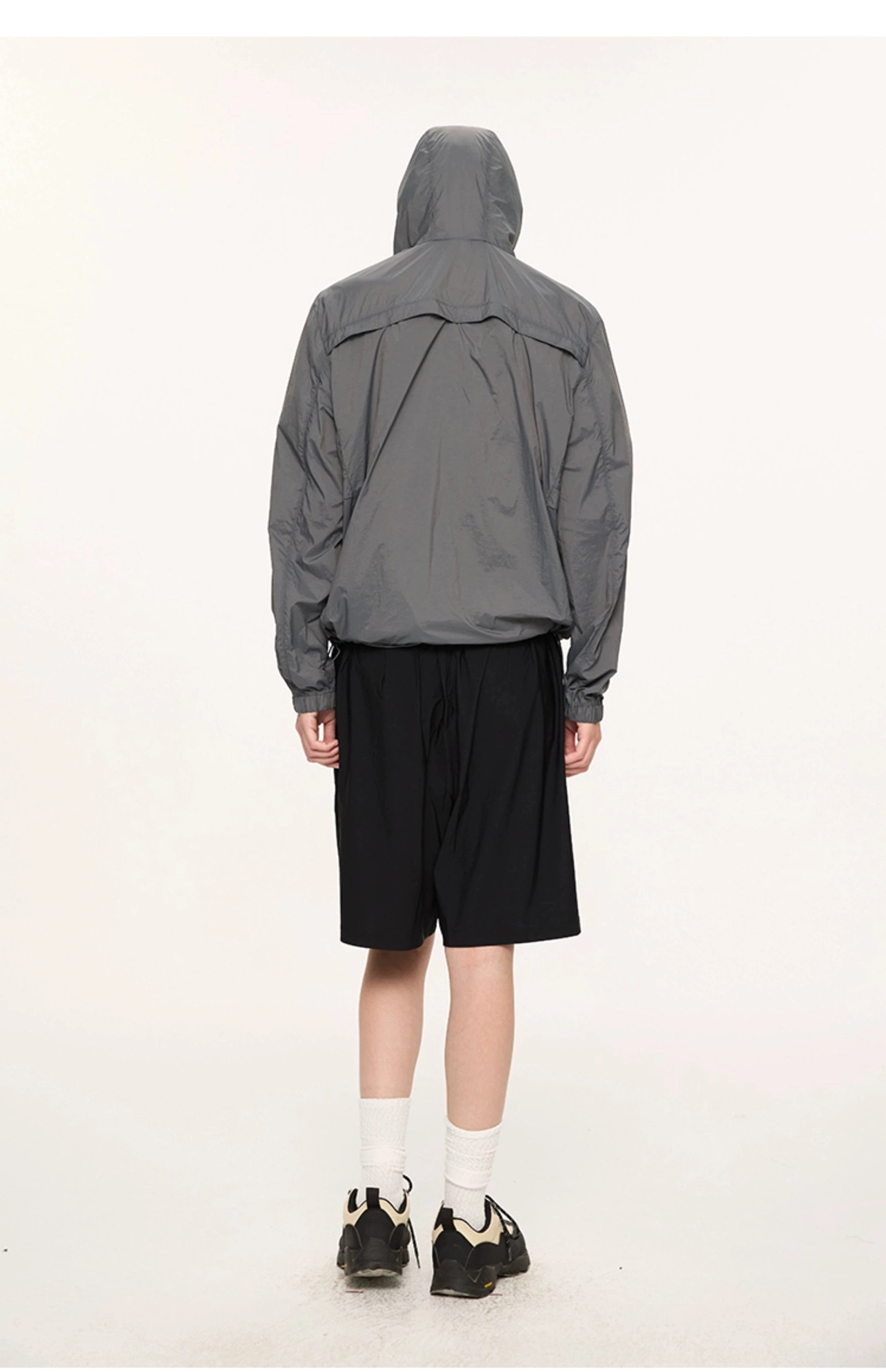 Full back view of dark gray lightweight sun protection jacket with hood and adjustable drawcord hem