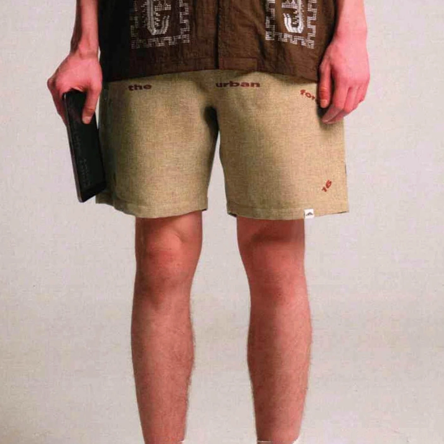 Khaki Urban Forest graphic sweat shorts front view with elastic waist, urban text print, and loose fit