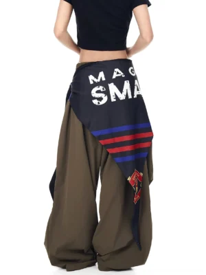 Back view of army green wide-leg streetwear cargo pants showing the black varsity scarf with lettering, stripe trims, and layered asymmetric styling