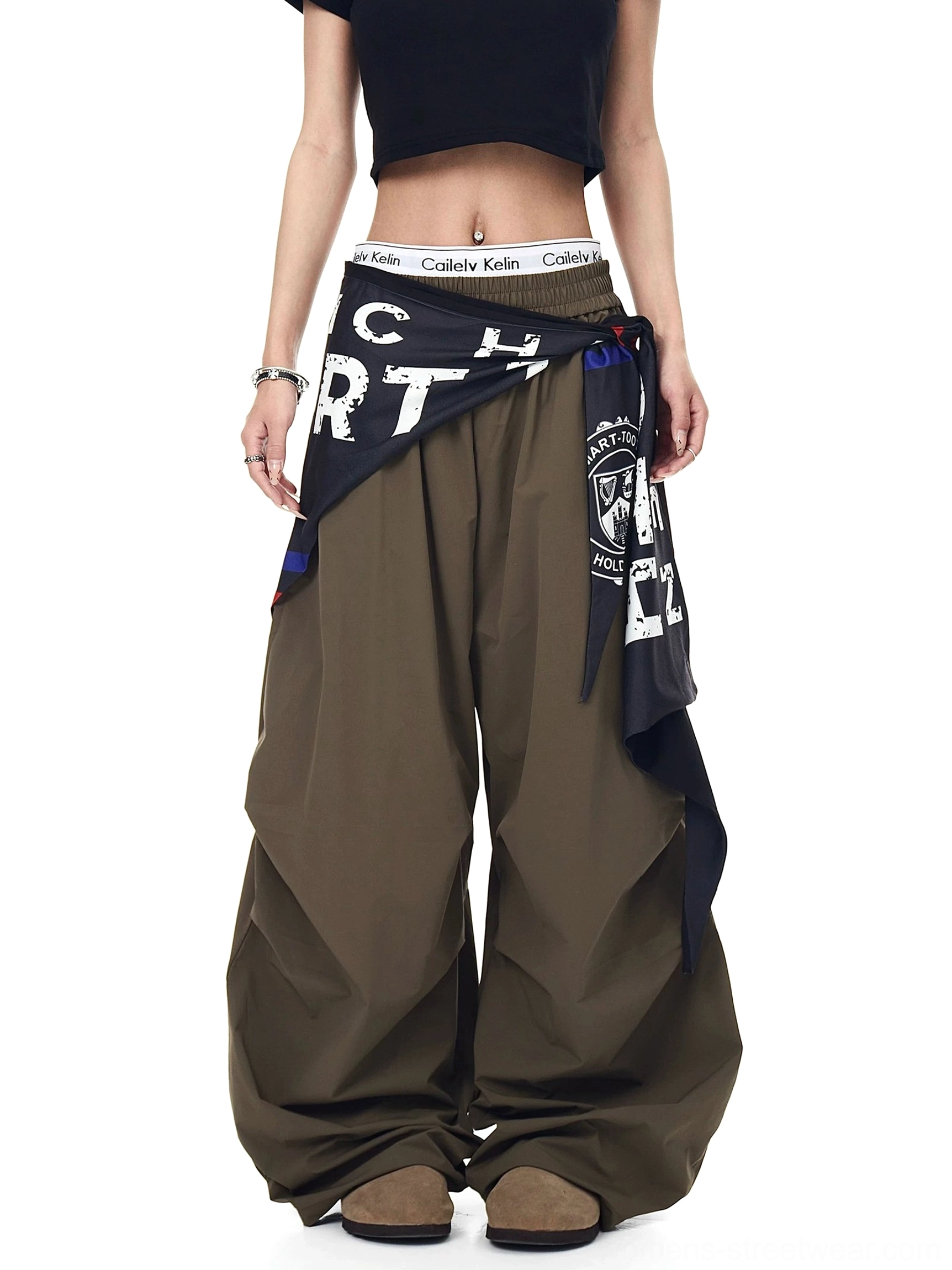 Front view of army green varsity scarf parachute cargo pants with an oversized wide-leg silhouette, elastic waistband, and detachable printed scarf styled with a cropped black tank top