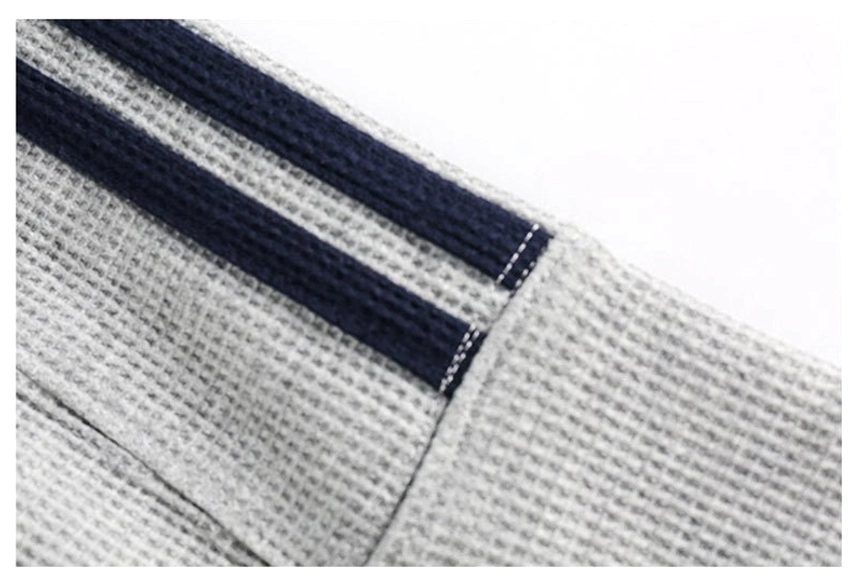 Close-up of contrast varsity sweatshirt sleeve stripe with navy fabric, white topstitching, and athletic streetwear detailing