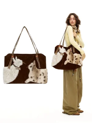 Velvet cat plush tote bag shown in Y2K streetwear styling with dark brown velvety body, dual cat appliques, and reinforced carry handles