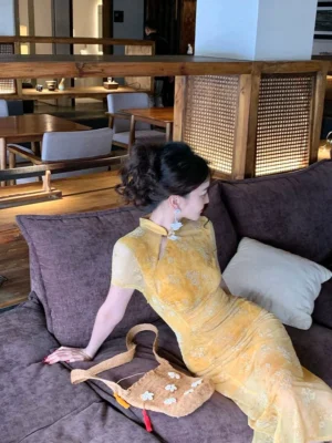 Vine-toned sheer floral cheongsam-inspired maxi dress with fitted floor-length silhouette styled in an elegant indoor setting