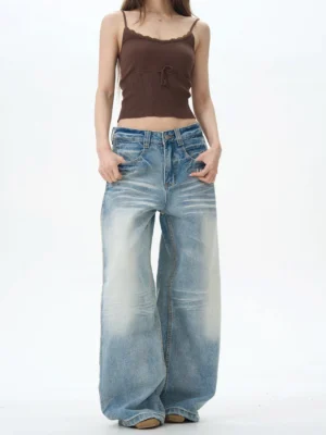 Front full body view of women wearing light blue vintage baggy wide leg jeans with high rise waist and faded streetwear denim wash