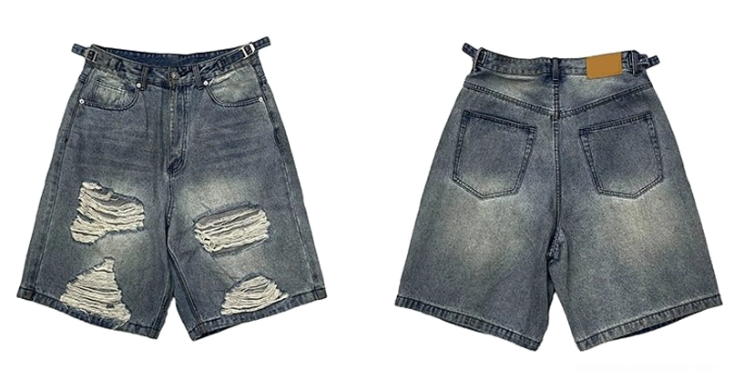 Flat lay of vintage blue distressed ripped denim Bermuda shorts showing front shredded panels and two back patch pockets