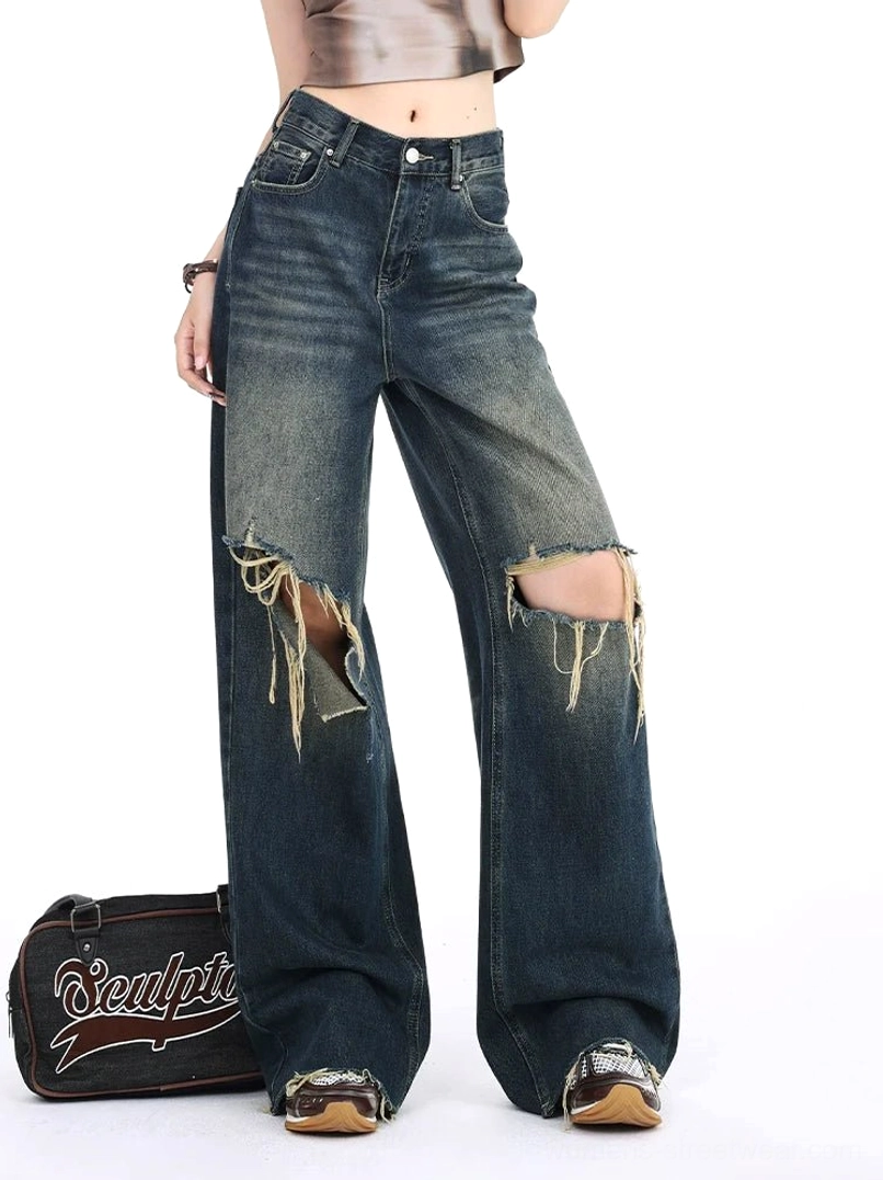 Front three-quarter view of vintage blue distressed wide leg jeans featuring a high-rise fit, double frayed knee rips, loose silhouette, dark gradient wash, and casual Y2K streetwear outfit