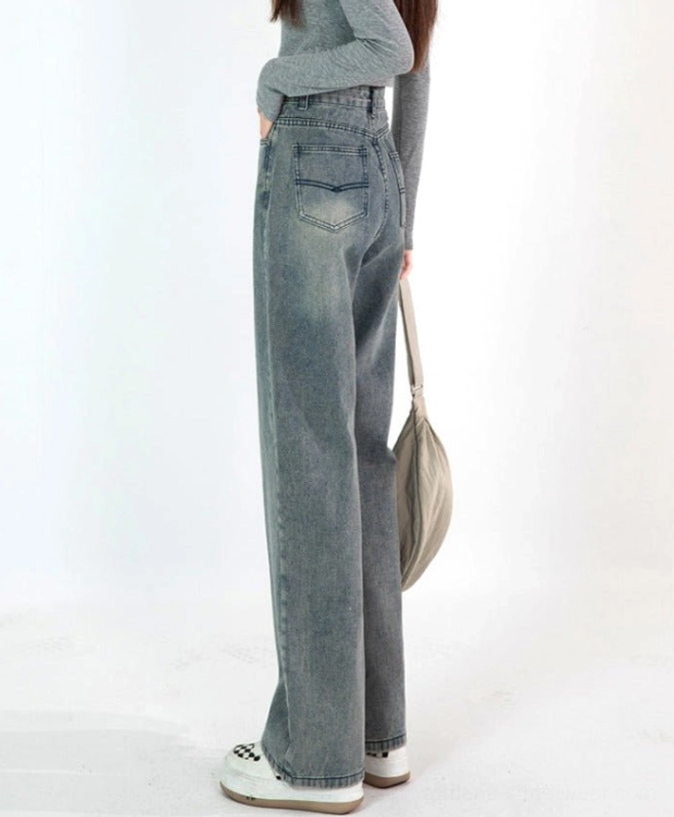 Rear side view of vintage blue faded wide-leg jeans showing the rear patch pocket, subtle leg fading, and relaxed streetwear fit