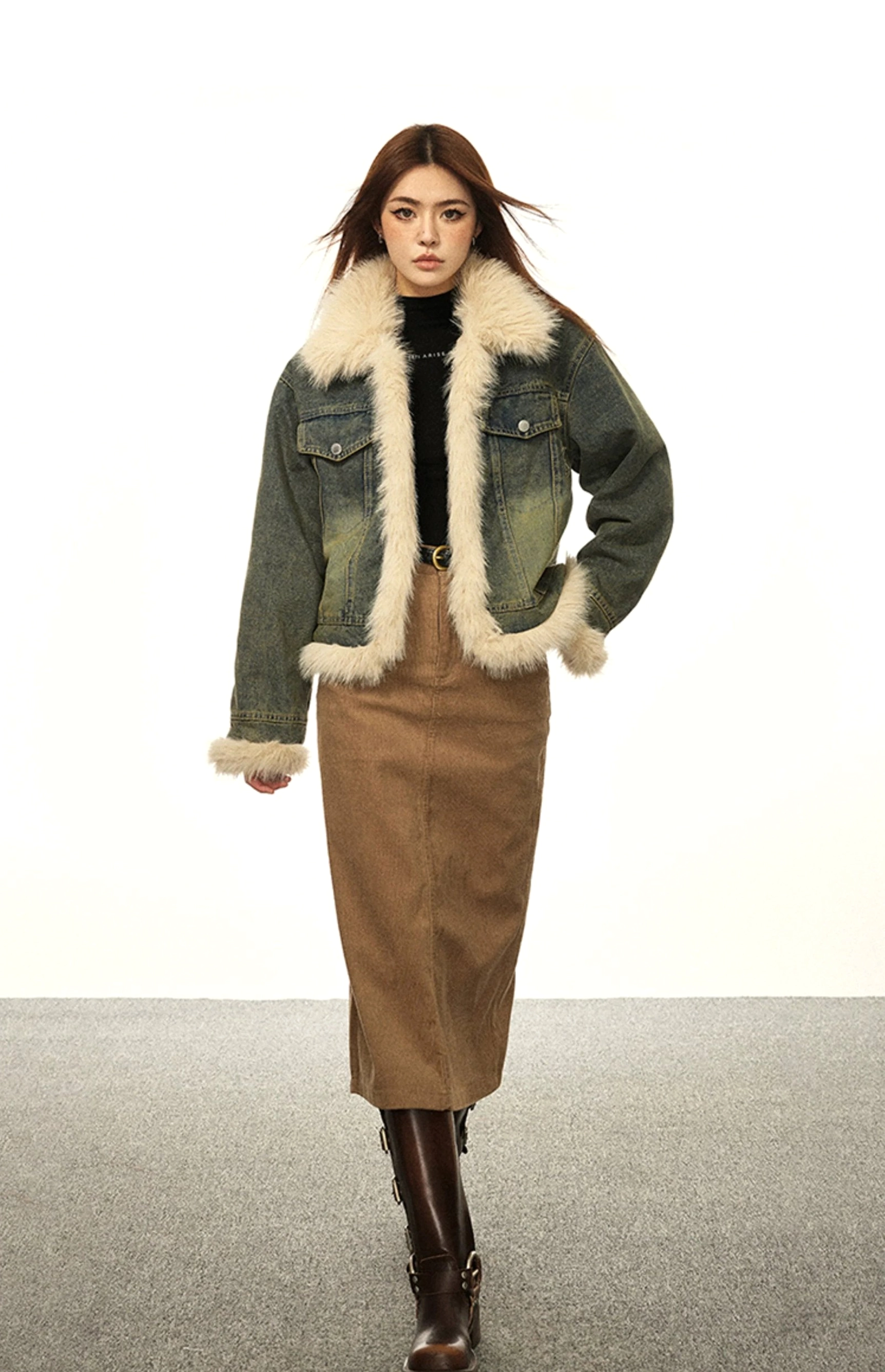 Full body rear side view of a vintage blue faux fur lined denim jacket styled with a brown skirt and leather boots