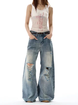 Vintage blue heavy distressed wide leg denim jeans front full body view with ripped knees