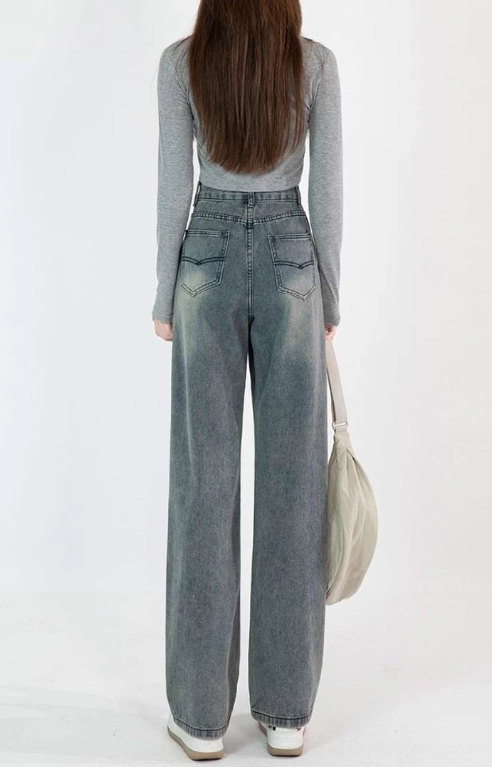 Back full-body view of high-waisted vintage blue wide-leg jeans with dual rear patch pockets and a clean full-length hem